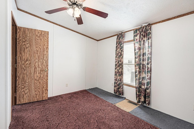 spare room with carpet floors, a textured ceiling, ornamental molding, and ceiling fan