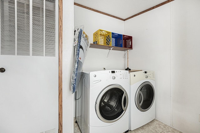 laundry area featuring washing machine and dryer and ornamental molding