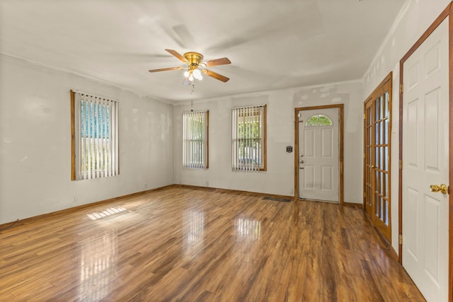 foyer featuring hardwood / wood-style flooring, ceiling fan, ornamental molding, and plenty of natural light