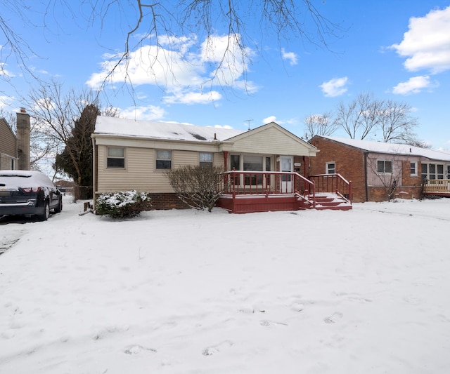 snow covered rear of property with covered porch