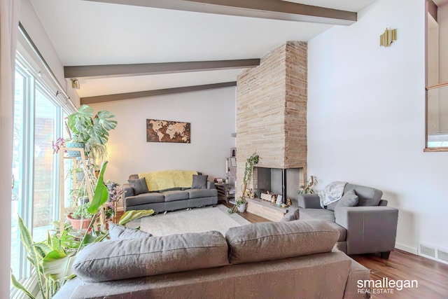 living room featuring lofted ceiling with beams, a fireplace, and hardwood / wood-style flooring