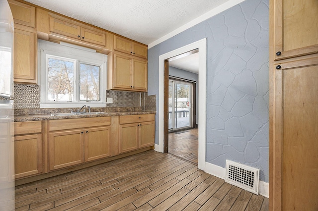 kitchen featuring a textured ceiling, tasteful backsplash, and sink