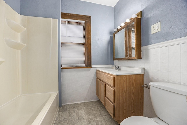 bathroom featuring toilet, tile walls, and vanity