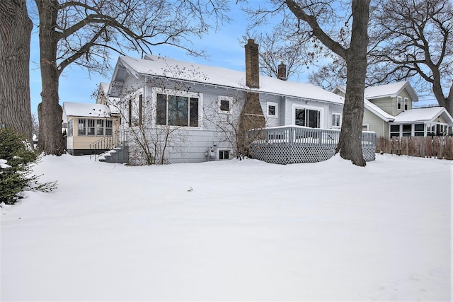 snow covered house featuring a deck