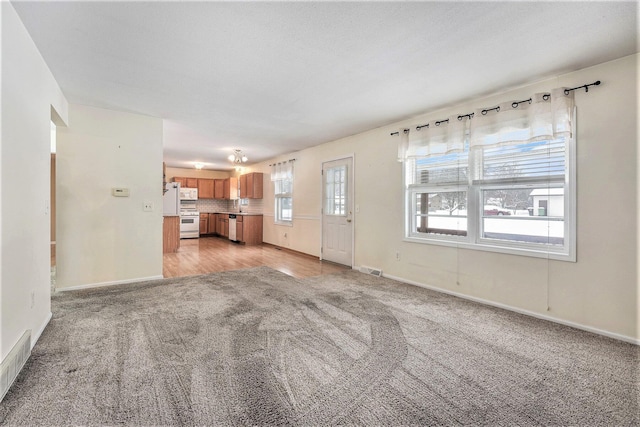 unfurnished living room featuring light colored carpet