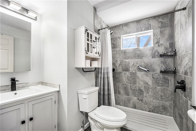 bathroom featuring toilet, vanity, and walk in shower