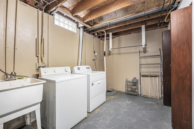 clothes washing area with separate washer and dryer and sink