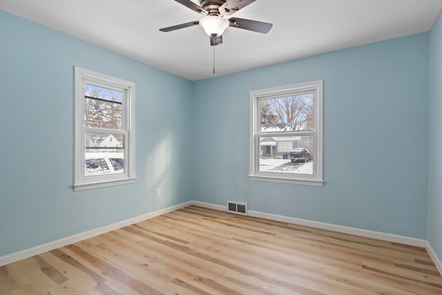 spare room featuring ceiling fan, a healthy amount of sunlight, and light hardwood / wood-style floors