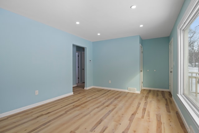 spare room with a wealth of natural light and light hardwood / wood-style flooring