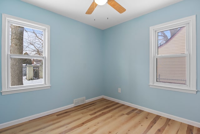 empty room with ceiling fan and light hardwood / wood-style flooring