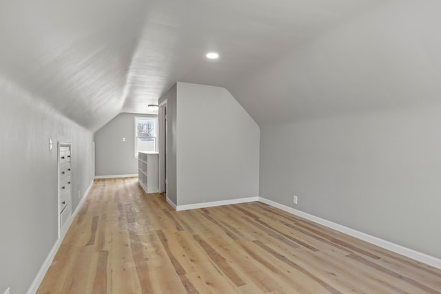 bonus room with vaulted ceiling and light hardwood / wood-style flooring