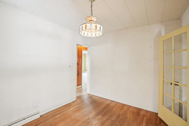 spare room with a baseboard radiator and hardwood / wood-style floors