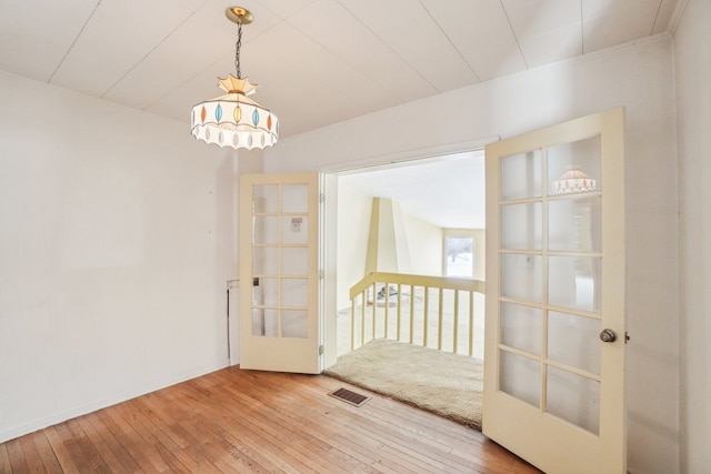 spare room featuring french doors and hardwood / wood-style floors