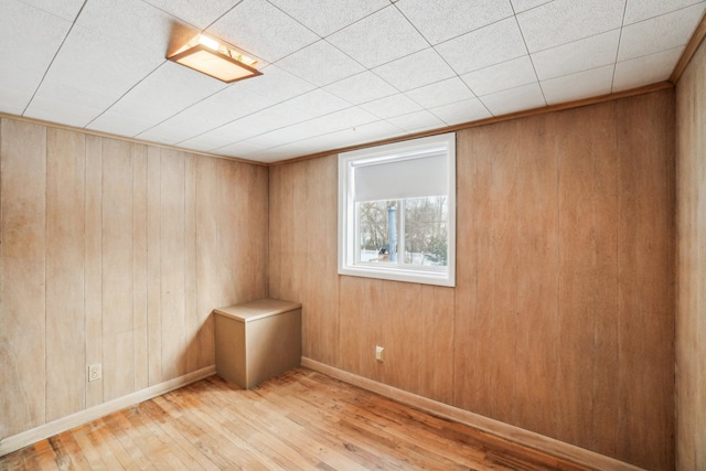 empty room featuring light hardwood / wood-style flooring and wooden walls