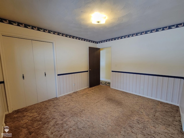 unfurnished bedroom with carpet floors and a closet