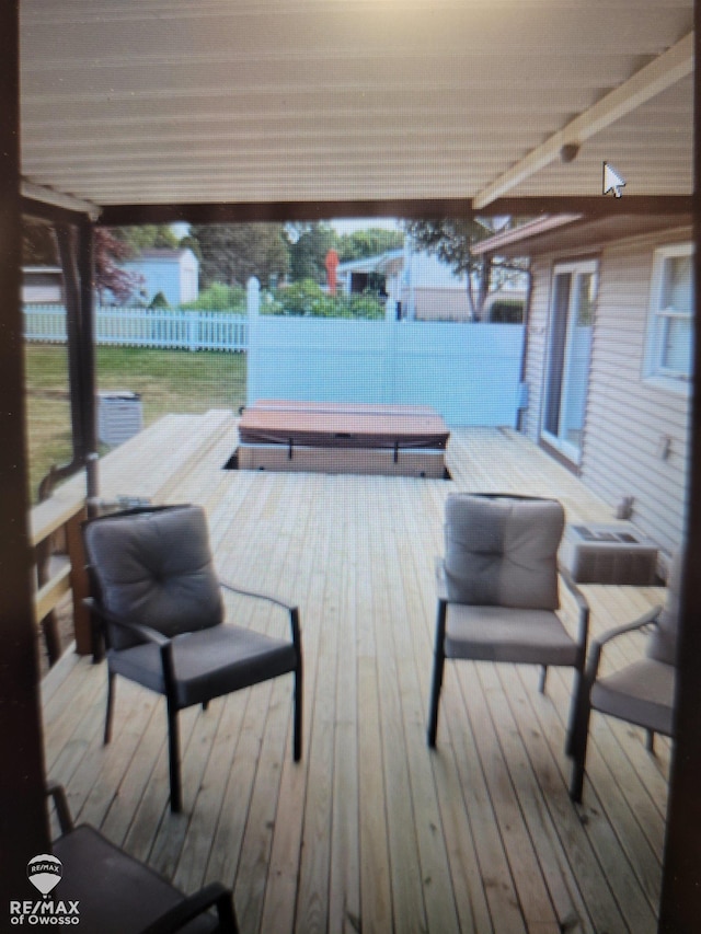 wooden deck with a covered hot tub