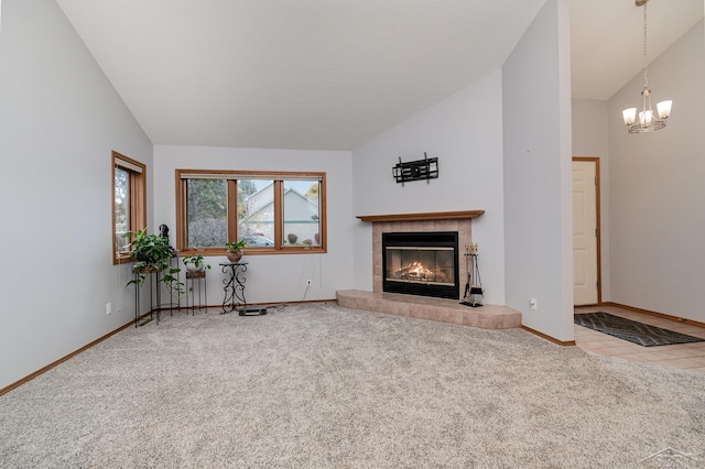 unfurnished living room featuring carpet, lofted ceiling, a notable chandelier, and a fireplace