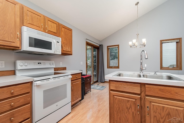 kitchen with an inviting chandelier, white appliances, vaulted ceiling, pendant lighting, and sink