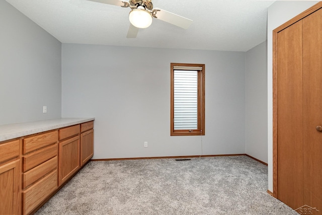 unfurnished bedroom featuring ceiling fan, light colored carpet, and a closet