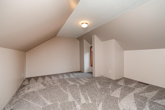 bonus room featuring carpet floors, a textured ceiling, and vaulted ceiling