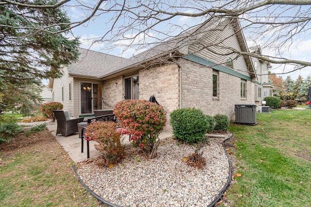 view of property exterior with a lawn, central air condition unit, and a patio