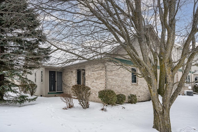 view of snowy exterior with central air condition unit