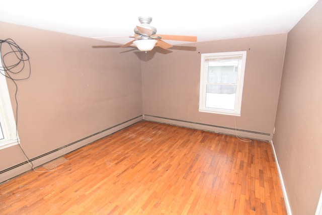 spare room with ceiling fan, a baseboard heating unit, and light hardwood / wood-style flooring