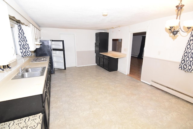 kitchen with an inviting chandelier, black oven, decorative light fixtures, a baseboard radiator, and sink