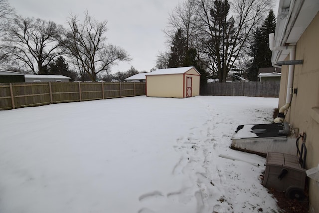 yard covered in snow with a shed