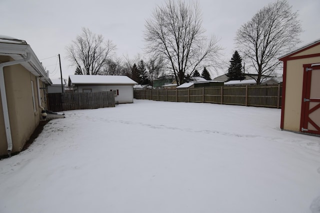 yard covered in snow featuring a shed