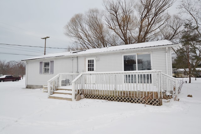 snow covered property with a deck