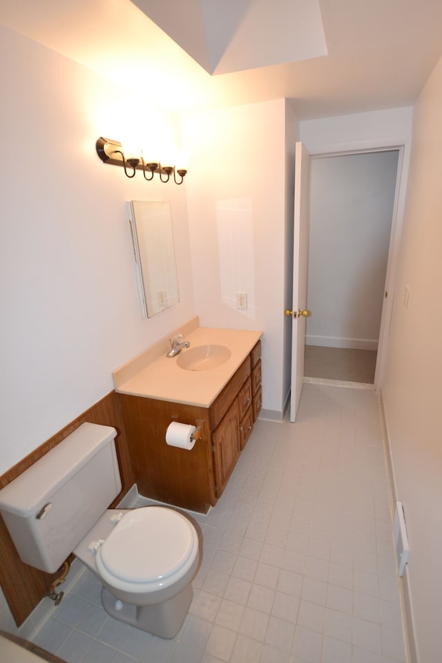 bathroom with toilet, tile patterned flooring, and vanity