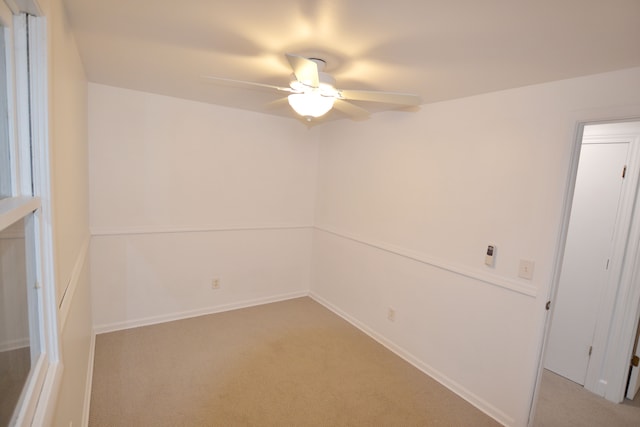 carpeted spare room featuring ceiling fan