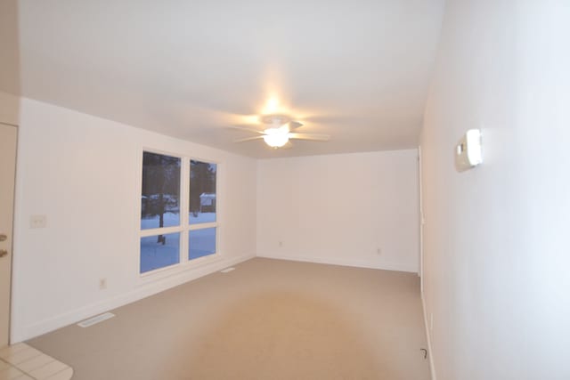 unfurnished room with ceiling fan and carpet