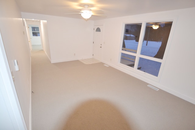 empty room featuring ceiling fan and carpet