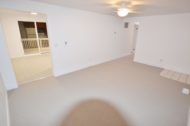 spare room with ceiling fan and carpet