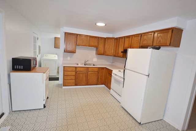 kitchen with sink, white appliances, and washer / clothes dryer