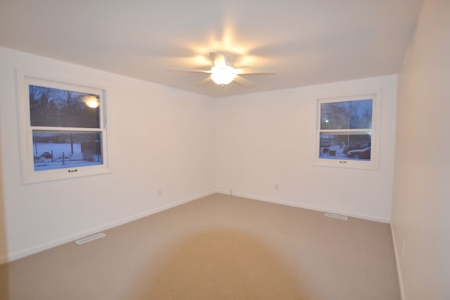 carpeted spare room with ceiling fan