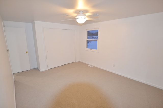 carpeted spare room featuring ceiling fan