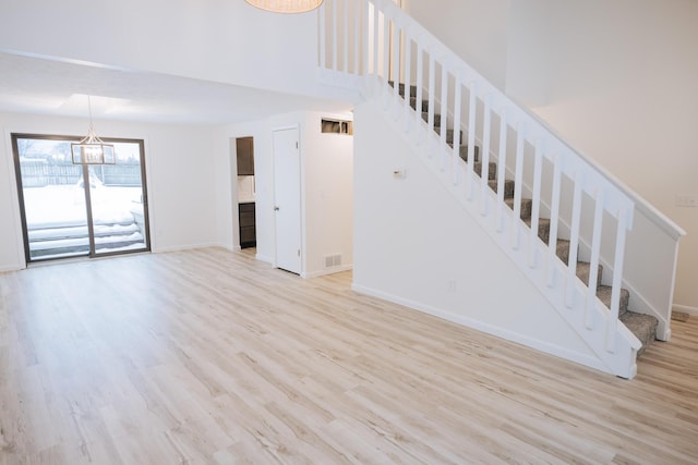 stairway with a chandelier and hardwood / wood-style floors