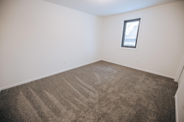 spare room featuring dark carpet