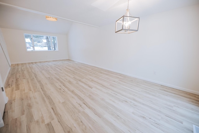 unfurnished room with light wood-type flooring, vaulted ceiling, and a chandelier