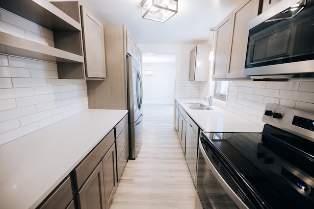 kitchen with stainless steel appliances, light brown cabinetry, light hardwood / wood-style floors, and sink