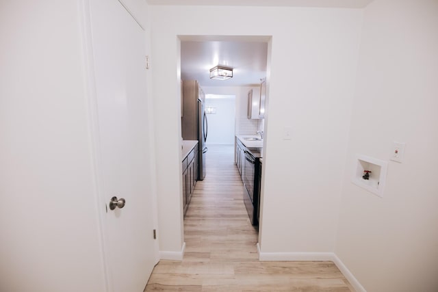 corridor featuring light hardwood / wood-style floors and sink