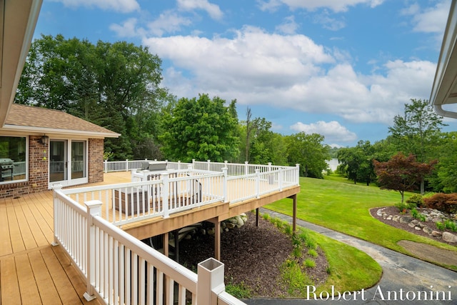 wooden deck featuring a lawn