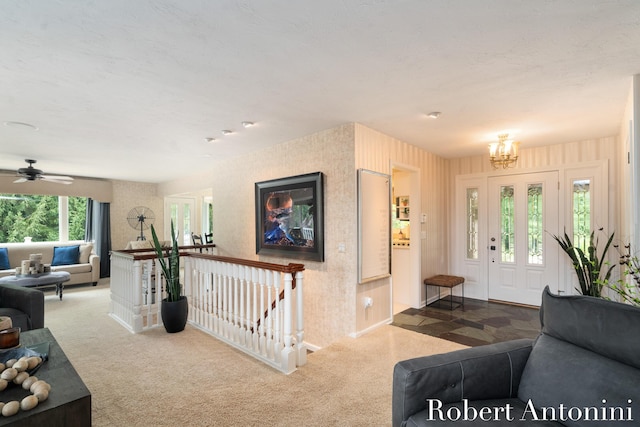 living room with carpet and ceiling fan with notable chandelier