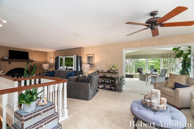 living room with ceiling fan, light colored carpet, and a fireplace