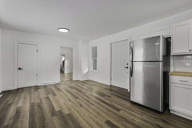 kitchen featuring dark wood-type flooring, white cabinets, and stainless steel fridge