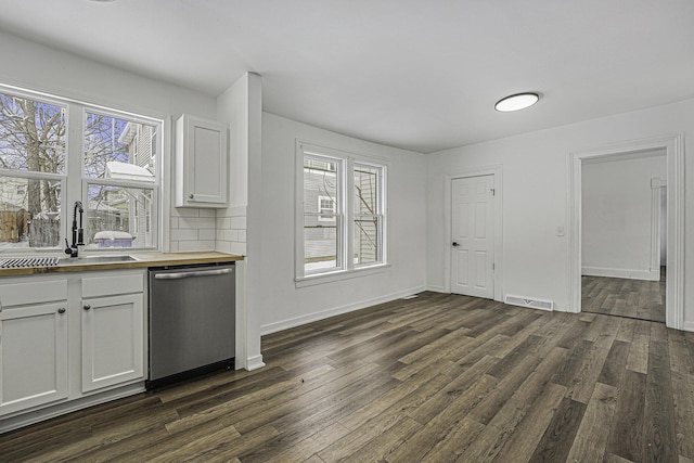 kitchen featuring white cabinetry, butcher block countertops, tasteful backsplash, dishwasher, and sink