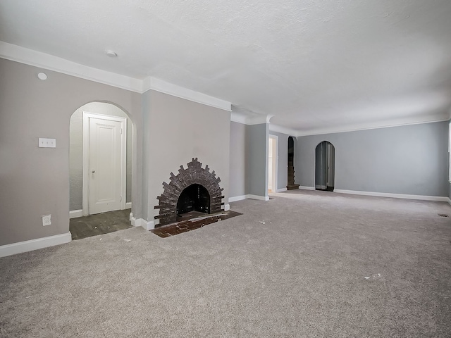 unfurnished living room with a textured ceiling, carpet flooring, crown molding, and a fireplace